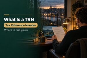 Tax reference number in Ireland: business owner at a desk at dusk checking a Revenue letter beside a laptop